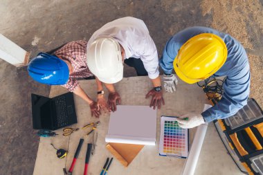 İnşaat mühendisi takım çalışması güvenlik ekibi, inşaat sahasında beyaz sarı şapkalı güvenlik ekipmanı tutuyor. Hardhat İnşaat Mühendisliği Mühendisliği Yöneticisini Koru