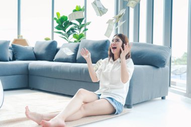 Elinde dolar olan mutlu Asyalı kadın mutluluğu kutluyor zenginliği kutluyor piyango parası yağmur damlası. Kazanan iş kadını para akışı yapar gülen surat