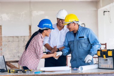 İnşaat mühendisi takım çalışması güvenlik ekibi, inşaat sahasında beyaz sarı şapkalı güvenlik ekipmanı tutuyor. Hardhat İnşaat Mühendisliği Mühendisliği Yöneticisini Koru