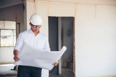 İnşaat mühendisi takım çalışması güvenlik ekibi, inşaat sahasında beyaz sarı şapkalı güvenlik ekipmanı tutuyor. Hardhat İnşaat Mühendisliği Mühendisliği Yöneticisini Koru