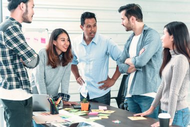 Çok ırklı iş adamlarından oluşan bir grup konferans salonunda iş dünyası grafiği ve grafiği üzerinde fikir alışverişinde bulunuyor. Çok Kültürlü Takım Çalışması, iş ortakları ve güven ortakları bir araya gelecek.