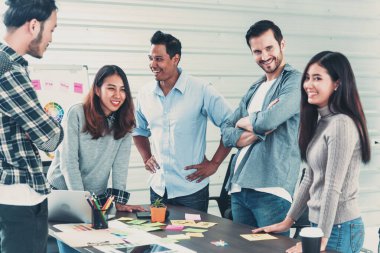 Çok ırklı iş adamlarından oluşan bir grup konferans salonunda iş dünyası grafiği ve grafiği üzerinde fikir alışverişinde bulunuyor. Çok Kültürlü Takım Çalışması, iş ortakları ve güven ortakları bir araya gelecek.