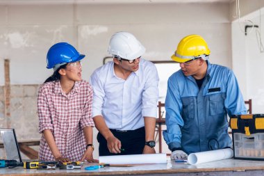 İnşaat mühendisi takım çalışması güvenlik ekibi, inşaat sahasında beyaz sarı şapkalı güvenlik ekipmanı tutuyor. Hardhat İnşaat Mühendisliği Mühendisliği Yöneticisini Koru