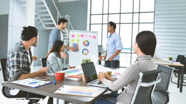 Çok ırklı iş adamlarından oluşan bir grup konferans salonunda iş dünyası grafiği ve grafiği üzerinde fikir alışverişinde bulunuyor. Çok Kültürlü Takım Çalışması, iş ortakları ve güven ortakları bir araya gelecek.