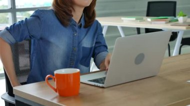 Ev bilgisayarında çalışan bir kadın merkez ofiste online toplantı yapıyor. Dizüstü bilgisayar kullanan girişimci Asyalı iş kadını kanepe teknolojisinde yeni normal yaşam tarzında oturuyor. Klavye dizüstü bilgisayarı yazan mutlu kadın