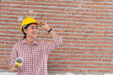 İnşaat işçisi kadın inşaat sektöründe güvenlik önlüğü takıyor. Sıkı kasklı inşaat mühendisi kadın mühendis. Kadın inşaat mühendisi konsepti