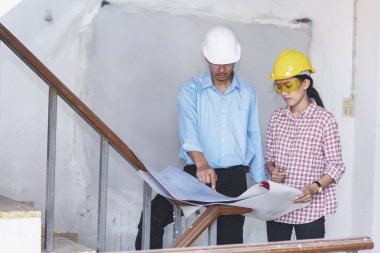 İnşaat mühendisi takım çalışması güvenlik ekibi, inşaat sahasında beyaz sarı şapkalı güvenlik ekipmanı tutuyor. Hardhat İnşaat Mühendisliği Mühendisliği Yöneticisini Koru