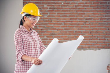 İnşaat işçisi kadın inşaat sektöründe güvenlik önlüğü takıyor. Sıkı kasklı inşaat mühendisi kadın mühendis. Kadın inşaat mühendisi konsepti