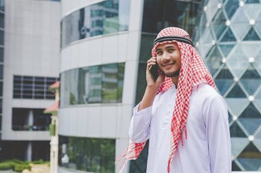 Akıllı telefon uygulaması kullanan İslami adam, ajandasını akıllı telefon Müslüman modern uae şehrine odaklıyor. Arap erkekleri tesettür ve Müslüman resmi giysileri giyer. Çevrimiçi yaşam tarzı mesajları gönderir.