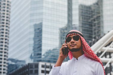 Akıllı telefon uygulaması kullanan İslami adam, ajandasını akıllı telefon Müslüman modern uae şehrine odaklıyor. Arap erkekleri tesettür ve Müslüman resmi giysileri giyer. Çevrimiçi yaşam tarzı mesajları gönderir.