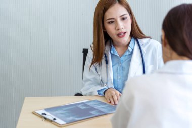 İki Asyalı kadın doktor, doktorun muayenehanesinde röntgen filmi danışmanlığı yapan hastalarla görüşmeyi tartışıyor. Asya tıp laboratuarındaki genç kadınlar birlikte sağlık hizmetleri hakkında konuşuyorlar.