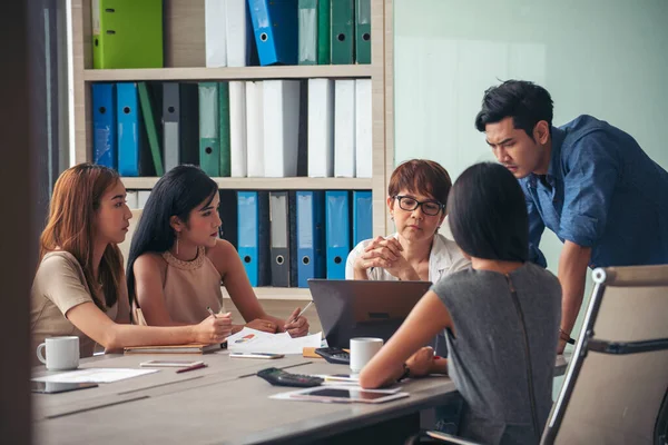 Happiness diversity business team meeting corporate office desk in company meeting room. Asian team group partner brainstorming discussion multiethnic people sitting share ideas teamwork in boardroom