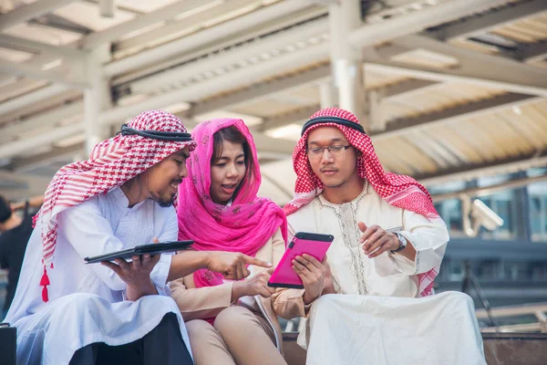 Dijital pazarlama grubu Arap insanlar modern müslüman BAE şehir dokunmatik ekran tartışmasında akıllı tablet kullanıyorlar. Girişimci Asyalı insanlar patronlarıyla dışarıda konuşurken gülümserler.