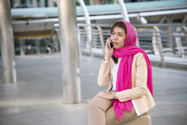 Islamic woman using smartphones app organize schedule agenda  focus on hands holding smartphone muslim modern uae city. Arab woman wear hijab and muslim formal dress sending text sms online lifestyle