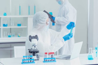 İki Asyalı bilim adamı kimya bilimi tüpü deney tüpü antikor örneğini kovid-19 virüsüne karşı laboratuvar geliştirmek için depoluyorlar. Kimya Laboratuarı 'nda bilim adamı danışmanı, analizi