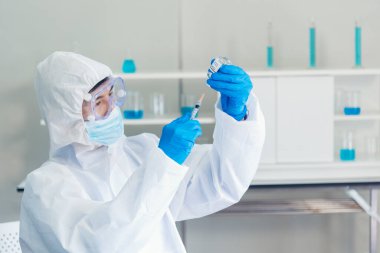 Bilim adamı covid-19 virüs kimya araştırması biyoteknoloji antikor örneği laboratuvarı virüse karşı aşı üretiyor. Bilim adamı mikroskoba bakıyor, bilim test tüpü kimya laboratuvarını analiz ediyor.