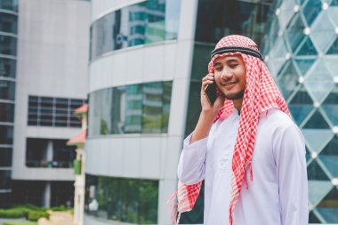 Akıllı telefon uygulaması kullanan İslami adam, ajandasını akıllı telefon Müslüman modern uae şehrine odaklıyor. Arap erkekleri tesettür ve Müslüman resmi giysileri giyer. Çevrimiçi yaşam tarzı mesajları gönderir.
