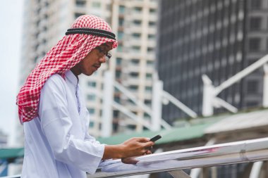 Akıllı telefon uygulaması kullanan İslami adam, ajandasını akıllı telefon Müslüman modern uae şehrine odaklıyor. Arap erkekleri tesettür ve Müslüman resmi giysileri giyer. Çevrimiçi yaşam tarzı mesajları gönderir.