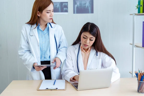 Dwie Azjatyckie Lekarki Dyskutują Spotkaniu Kliniką Lekarską Przy Użyciu Laptopa — Zdjęcie stockowe