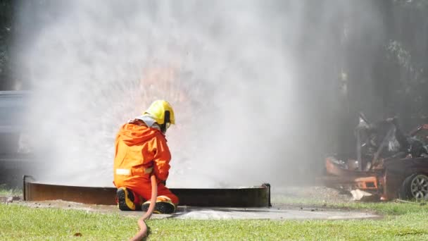 消火ホース化学水フォームスプレーエンジンを使用して炎と戦う消防士 消防士は 保護のためのハード帽子 ボディセーフスーツの制服を着用してください 消火器の救助訓練 — ストック動画