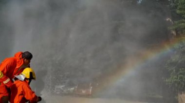 İtfaiyeci yangın hortumuyla, kimyasal köpüklü sprey motorla savaşıyor. İtfaiyeciler korunmak için kasketli, vücut korumalı üniformalı üniforma giyer. Yangın söndürücüde kurtarma eğitimi.