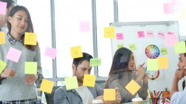 Çeşitli etnik gruplar, iş ortağıyla toplantı yapan ve konferans odasında fikirlerini paylaşan beyin fırtınası yapan gruplar. Yaratıcı tasarım meslektaşı strateji planı yapışkan notlar kullan, sunum fikirleri
