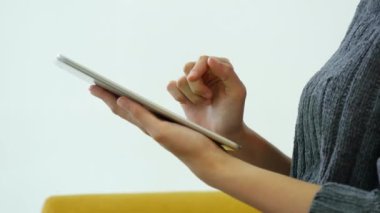 İnternetten dijital tablet alışverişi yapan Asyalı bir kadın arıyor, mesaj yolluyor, internet teknolojisi yaşam tarzında gülümsüyor. Asyalı kadın akıllı tablete dokunuyor mobil uygulama ev ofisini kullanarak ellere odaklanıyor.