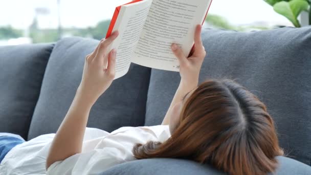 Relaks Azjatycka Kobieta Czyta Książkę Siedzi Kanapie Salonie Trzymając Książkę — Wideo stockowe