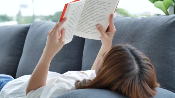 Relájese Mujer Asiática Leyendo Libro Sentado Sofá Sala Estar Sosteniendo — Vídeos de Stock