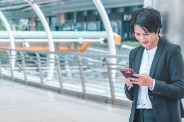 İş kadını internet üzerinden akıllı telefon alışverişi yapıyor, arıyor, internet teknolojisi yaşam tarzı mesaj yolluyor. Şehir caddesinde cep telefonu kullanan Asyalı kadın. Akıllı telefon akıllı, kendine güvenen kadın modern şehir.