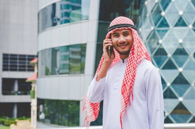 Akıllı telefon uygulaması kullanan İslami adam, ajandasını akıllı telefon Müslüman modern uae şehrine odaklıyor. Arap erkekleri tesettür ve Müslüman resmi giysileri giyer. Çevrimiçi yaşam tarzı mesajları gönderir.