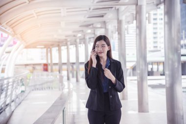 İş kadını internet üzerinden akıllı telefon alışverişi yapıyor, arıyor, internet teknolojisi yaşam tarzı mesaj yolluyor. Şehir caddesinde cep telefonu kullanan Asyalı kadın. Akıllı telefon akıllı, kendine güvenen kadın modern şehir.