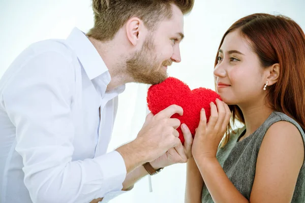 Couple lover in love smile and looking eyes each other with happiness romantic relationship. Couple lover holding red heart shape symbol of love. Close up face shot love at first sight flirting date