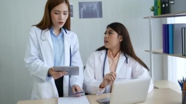 İki Asyalı kadın doktor, doktorun muayenehanesinde röntgen filmi danışmanlığı yapan hastalarla görüşmeyi tartışıyor. Asya tıp laboratuarındaki genç kadınlar birlikte sağlık hizmetleri hakkında konuşuyorlar.