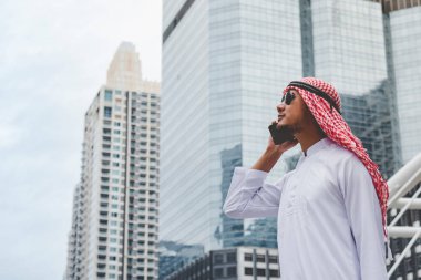 Akıllı telefon uygulaması kullanan İslami adam, ajandasını akıllı telefon Müslüman modern uae şehrine odaklıyor. Arap erkekleri tesettür ve Müslüman resmi giysileri giyer. Çevrimiçi yaşam tarzı mesajları gönderir.