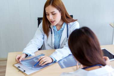 İki Asyalı kadın doktor, doktorun muayenehanesinde röntgen filmi danışmanlığı yapan hastalarla görüşmeyi tartışıyor. Asya tıp laboratuarındaki genç kadınlar birlikte sağlık hizmetleri hakkında konuşuyorlar.