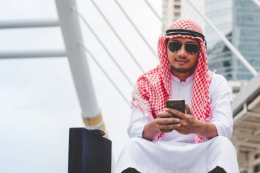 Akıllı telefon uygulaması kullanan İslami adam, ajandasını akıllı telefon Müslüman modern uae şehrine odaklıyor. Arap erkekleri tesettür ve Müslüman resmi giysileri giyer. Çevrimiçi yaşam tarzı mesajları gönderir.