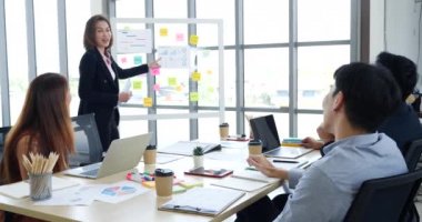 Mutlu iş adamları toplantı odasında grafik çizelgesi yatırımıyla ve iş verileriyle tanışıyor. Bir grup iş adamı konferans odasında toplanıyor. Asyalı iş adamı konuşması, mevcut takım çalışması ortaklığı