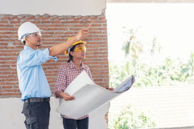 İnşaat mühendisi takım çalışması güvenlik ekibi, inşaat sahasında beyaz sarı şapkalı güvenlik ekipmanı tutuyor. Hardhat İnşaat Mühendisliği Mühendisliği Yöneticisini Koru