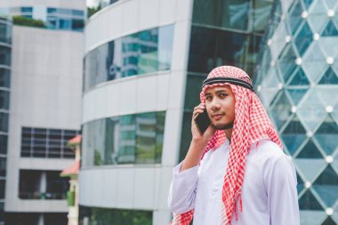 Akıllı telefon uygulaması kullanan İslami adam, ajandasını akıllı telefon Müslüman modern uae şehrine odaklıyor. Arap erkekleri tesettür ve Müslüman resmi giysileri giyer. Çevrimiçi yaşam tarzı mesajları gönderir.