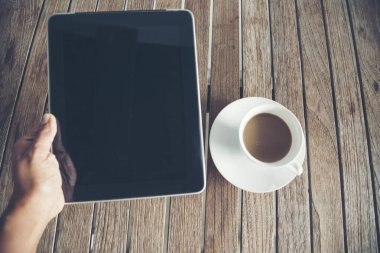 Üst görüşlü adam ofis bilgisayarını ahşap masa fotokopi alanındaki kahve fincanını verdi. Masaüstü dizüstü dizüstü bilgisayarlı kahve fincanı, memurun ahşap arka planda boş yer göstermesi için. Ev çalışma alanından çalış.