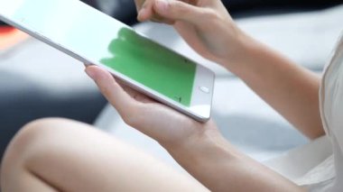 İnternetten dijital tablet alışverişi yapan Asyalı bir kadın arıyor, mesaj yolluyor, internet teknolojisi yaşam tarzında gülümsüyor. Asyalı kadın akıllı tablete dokunuyor mobil uygulama ev ofisini kullanarak ellere odaklanıyor.