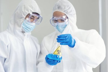 İki Asyalı bilim adamı kimya bilimi tüpü deney tüpü antikor örneğini kovid-19 virüsüne karşı laboratuvar geliştirmek için depoluyorlar. Kimya Laboratuarı 'nda bilim adamı danışmanı, analizi