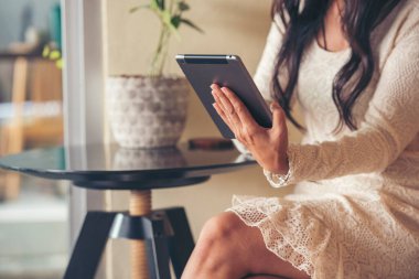 İnternetten dijital tablet alışverişi yapan Asyalı bir kadın arıyor, mesaj yolluyor, internet teknolojisi yaşam tarzında gülümsüyor. Asyalı kadın akıllı tablete dokunuyor mobil uygulama ev ofisini kullanarak ellere odaklanıyor.