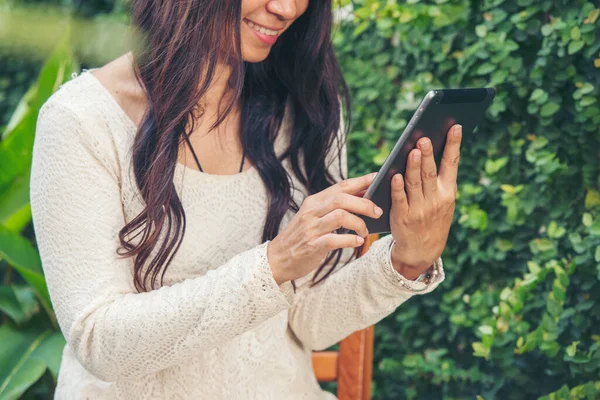 Asian woman using digital tablet shopping online, call, texting message internet technology lifestyle with smiling face. Asian woman touch smart tablet focus on hands using mobile app home office.