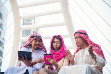 Dijital pazarlama grubu Arap insanlar modern müslüman BAE şehir dokunmatik ekran tartışmasında akıllı tablet kullanıyorlar. Girişimci Asyalı insanlar patronlarıyla dışarıda konuşurken gülümserler.