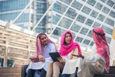 Dijital pazarlama grubu Arap insanlar modern müslüman BAE şehir dokunmatik ekran tartışmasında akıllı tablet kullanıyorlar. Girişimci Asyalı insanlar patronlarıyla dışarıda konuşurken gülümserler.