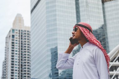 Akıllı telefon uygulaması kullanan İslami adam, ajandasını akıllı telefon Müslüman modern uae şehrine odaklıyor. Arap erkekleri tesettür ve Müslüman resmi giysileri giyer. Çevrimiçi yaşam tarzı mesajları gönderir.