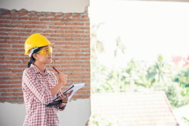İnşaat işçisi kadın inşaat sektöründe güvenlik önlüğü takıyor. Sıkı kasklı inşaat mühendisi kadın mühendis. Kadın inşaat mühendisi konsepti