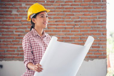İnşaat işçisi kadın inşaat sektöründe güvenlik önlüğü takıyor. Sıkı kasklı inşaat mühendisi kadın mühendis. Kadın inşaat mühendisi konsepti